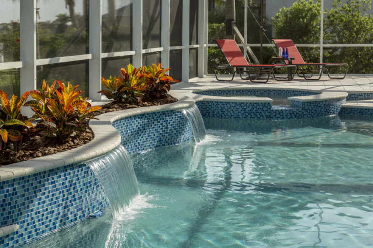 a pool with a waterfall and chairs