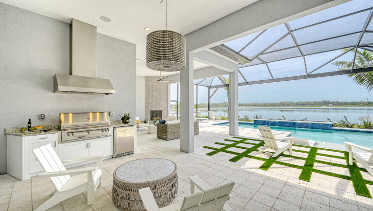 Luxury outdoor kitchen and poolside lounge with lake view