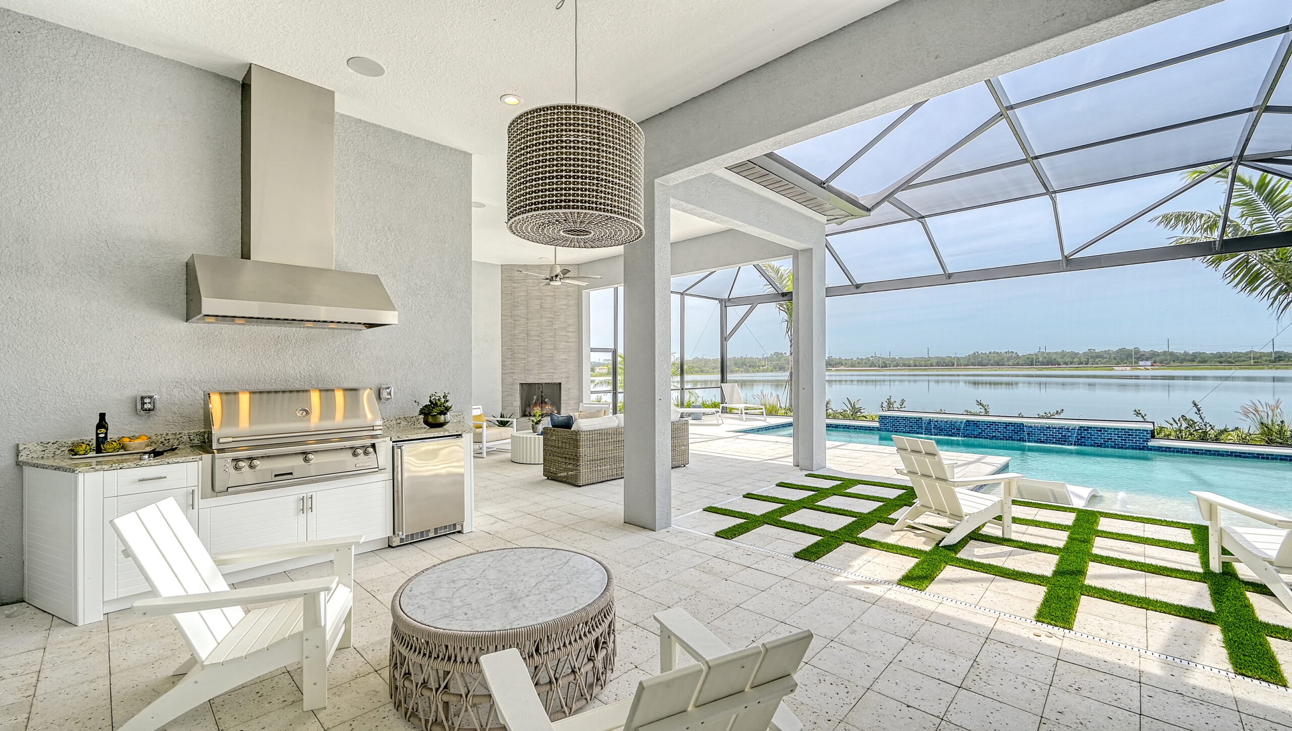 Luxury outdoor kitchen and poolside lounge with lake view