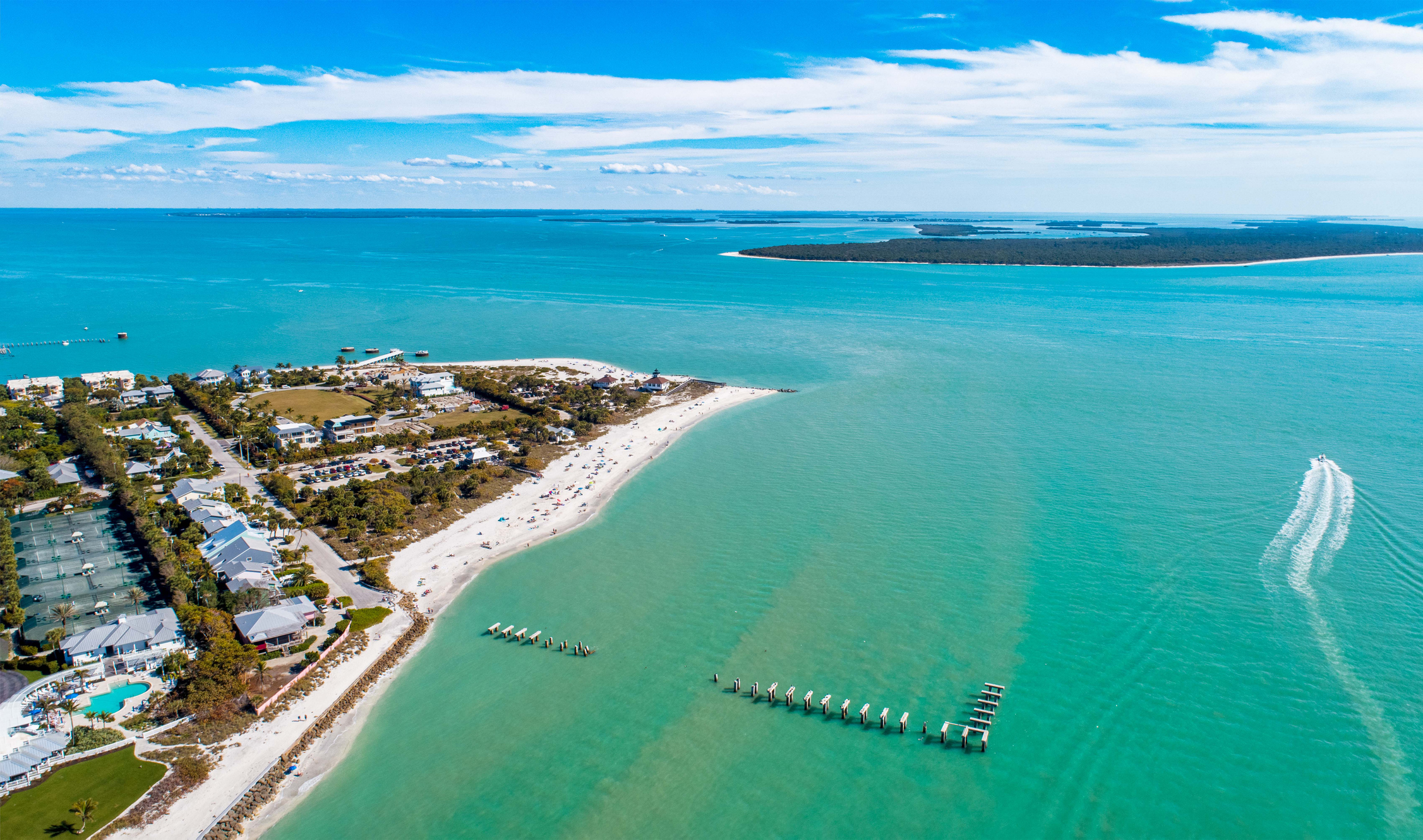 Captiva Island beach and turquoise Gulf of Mexico waters in Southwest Florida with coastal homes and boat.